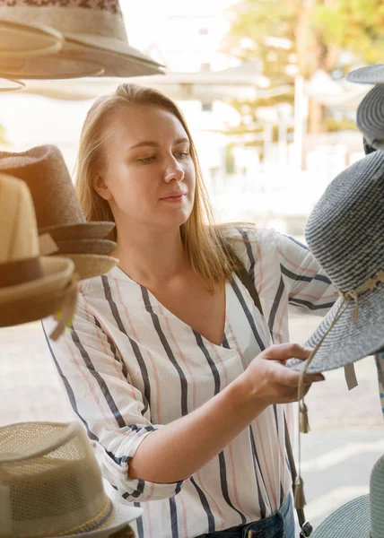 Mooie vrouw kiezen hoed in winkel. — Stockfoto