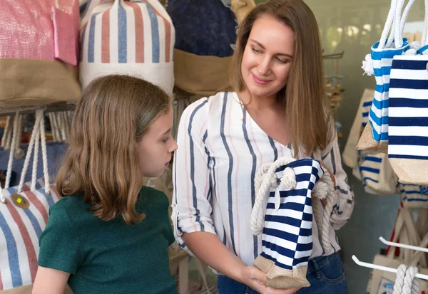 Vrouw en haar dochter kiezen strandtas in de winkel. — Stockfoto