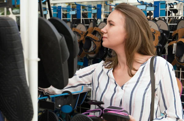 Mooie vrouw die teenslippers kiest in de winkel op vakantie. — Stockfoto