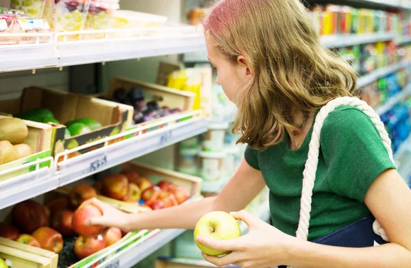 Gadis kecil cantik memilih apel di supermarket . — Stok Foto