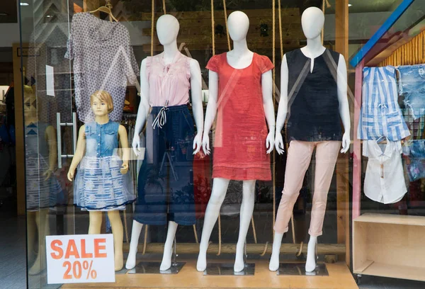 Mankenler yazlık kıyafetleri camın arkasında reklamını yaparlar..