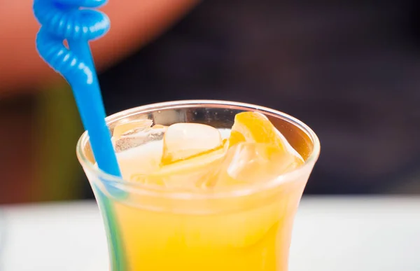 Orange cocktail in a glass with a plastic straw. — Stock Photo, Image