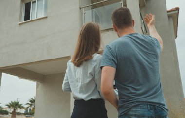 Emlakçı gelişimini müşterisine gösteriyor..