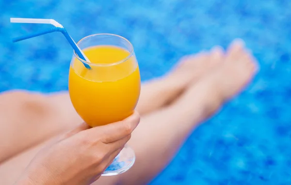 Kvinna Som Sitter Nära Poolen Och Håller Glas Med Apelsinjuice — Stockfoto