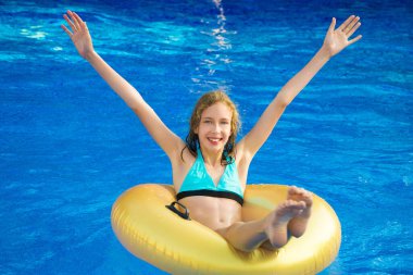 Yüzme havuzunda eğleniyor şişirilebilir kauçuk halka olan küçük kız. Metin için yer.