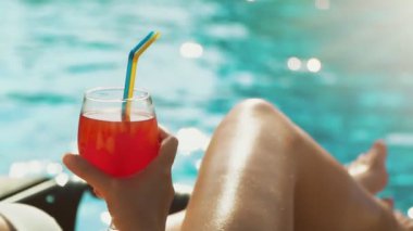 Yüzme havuzunun yanında dinlenen kokteyl içen kadın..