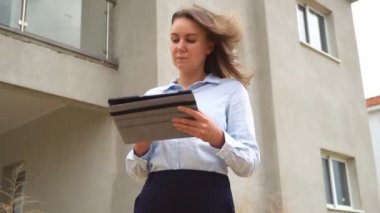 Yeni binanın önünde çalışan bir kadın müteahhit..