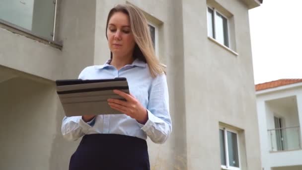 Entrepreneur féminin devant la nouvelle construction du bâtiment . — Video