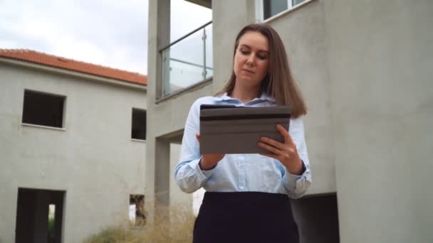 Contratista femenina frente a la construcción de un edificio nuevo . — Vídeo de stock