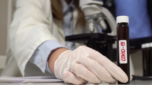 Científico en laboratorio poniendo tubo de muestra Covid-19 . — Vídeos de Stock