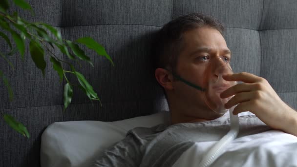Hombre enfermo con máscara inhaladora en la cara en la cama . — Vídeos de Stock