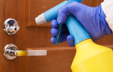 Koruyucu eldiveni alkol sıvısıyla birlikte ver. Covid-19 dezenfeksiyon konsepti.