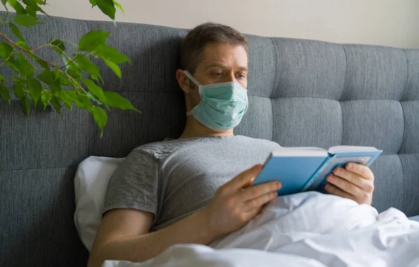Hombre Enfermo Con Máscara Médica Leyendo Libro Cama Concepto Cuarentena —  Fotos de Stock