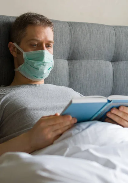 Hombre Enfermo Con Máscara Médica Leyendo Libro Cama Concepto Cuarentena —  Fotos de Stock