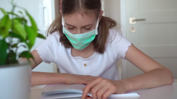 Meisje leest leerboek tijdens quarantaine. — Stockvideo