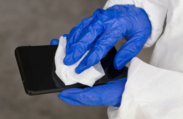 ナプキンクリーニング携帯電話で保護手袋を手 Covid 19消毒コンセプト — ストック写真