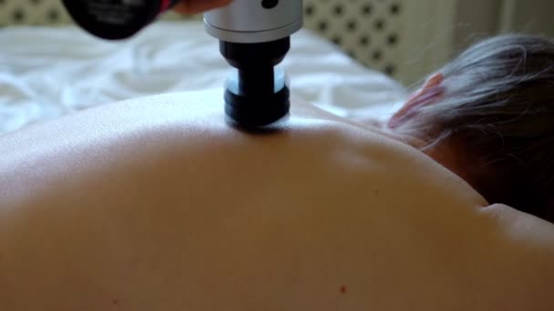 Der Mann Massiert Den Rücken Der Frau Mit Einem Massagegerät — Stockvideo