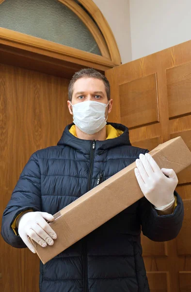 医療用マスクと手袋の男性宅配便小包と — ストック写真