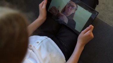 Küçük kız okul öğretmeniyle video görüşmesi yapıyor. Uzaklık öğrenimi.