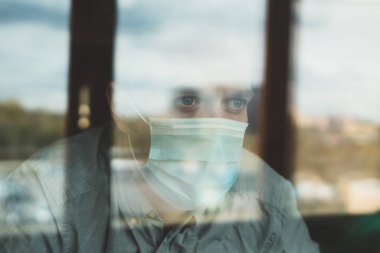 Kendini tecrit sırasında pencerenin arkasındaki adam. Evde kal..