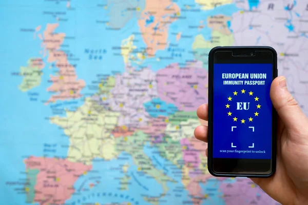 Man holding phone with European Immunity passport app. Travel during Covid-19 concept.