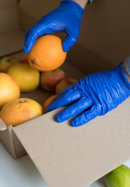 Voluntariado Guantes Médicos Protectores Poniendo Frutas Caja Donaciones —  Fotos de Stock