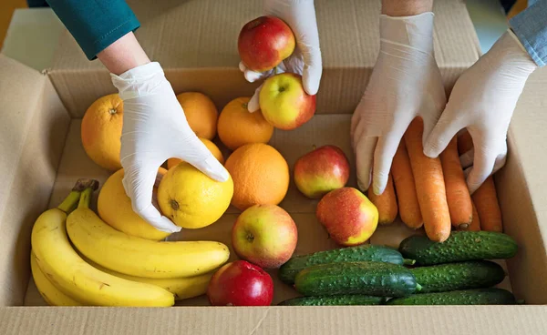Voluntarios Guantes Médicos Protectores Poniendo Frutas Verduras Caja Donaciones —  Fotos de Stock