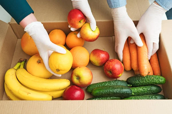 Voluntarios Guantes Médicos Protectores Poniendo Frutas Verduras Caja Donaciones —  Fotos de Stock