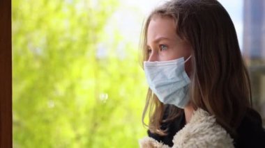 Kendini izole ederken balkonda oyuncak taşıyan küçük bir kız. Evde kal..