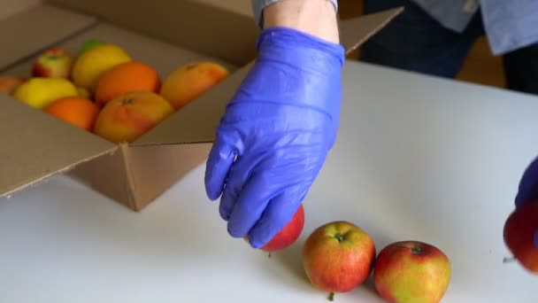 身穿防护服的志愿者和捐赠箱中的水果 — 图库视频影像