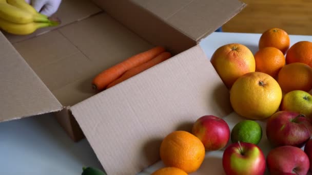 Voluntários Luvas Médicas Protetoras Colocando Frutas Legumes Caixa Doação — Vídeo de Stock