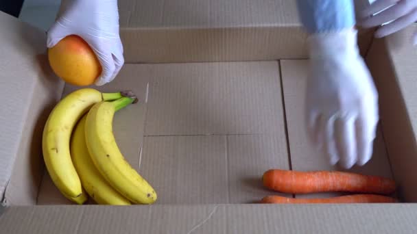 Voluntarios Guantes Médicos Protectores Poniendo Frutas Verduras Caja Donaciones — Vídeo de stock