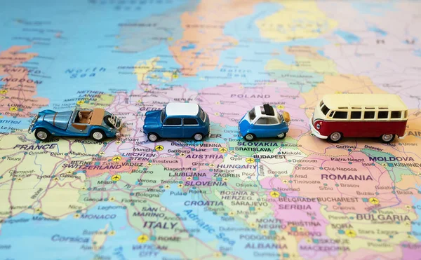 Set of small toy retro cars on the Europe map. Travel by car concept.