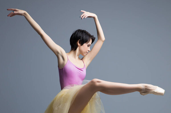 ballerina is dancing in the studio on a gray background