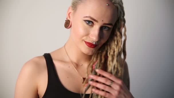 Moderní mládež. portrét klidné krásné dívky nestandardní vzhledu - dredy, piercing a tetování. — Stock video