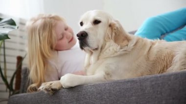 Evcil hayvan bakımı. Sarışın kız oturma odasında aşk köpeğiyle sıvazlar. aile içinde mutlu altın geri almak.