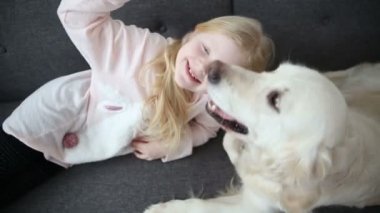 aşk için pets. küçük kız köpeğini oturma odasında kanepede ile dinleniyor.