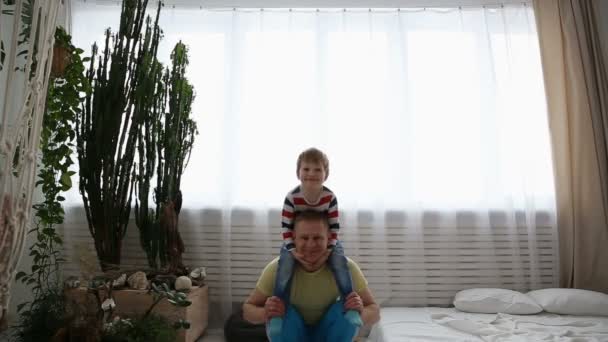 Moderne gesunde Familie. Papa und sein kleiner Sohn treiben zu Hause Sport. — Stockvideo