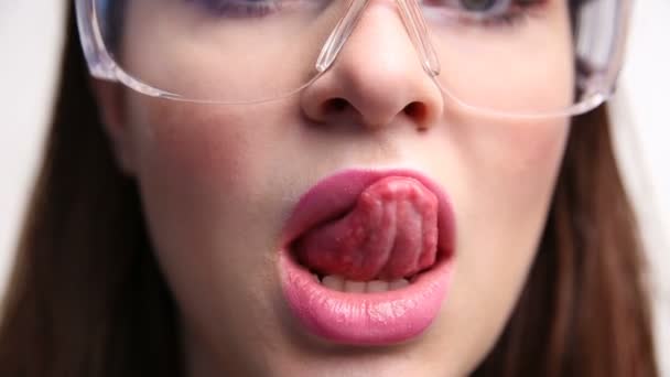 Twarz sexy kobiety w budowie zbliżenie okulary. Dziewczyna lizać jej usta erotycznie. — Wideo stockowe
