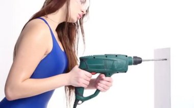 seksi kız matkaplar üzerinde beyaz bir stüdyo bir matkap ile. kavram - güzellik ve güç, feminizm