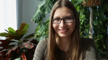 evde çalışıyorum. genç güzel kadın pencerenin evde - tatlı masasında çalışıyor. yaşayan bitkiler ile modern ekolojik iç.