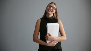 gri bir duvar yakınındaki belgelerle iş kız portresi. çalışan kadın mutlu ofis.