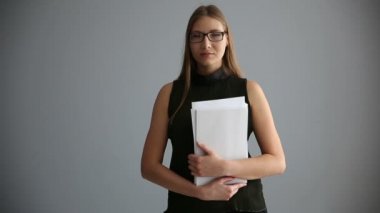 gri bir duvar yakınındaki belgelerle iş kız portresi. çalışan kadın ciddi ofis.