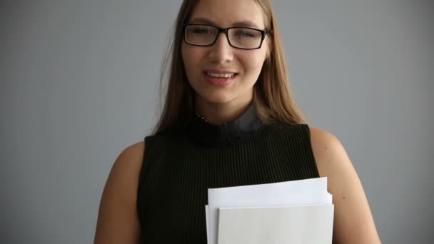 Portrait d'une femme d'affaires avec des documents près d'un mur gris. heureux employé de bureau femme . — Video