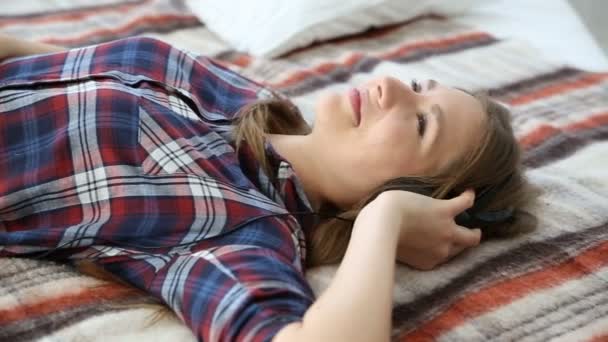Appareils électroniques dans la vie de la jeunesse moderne. jeune adolescente reposant à la maison sur le lit avec téléphone mobile . — Video