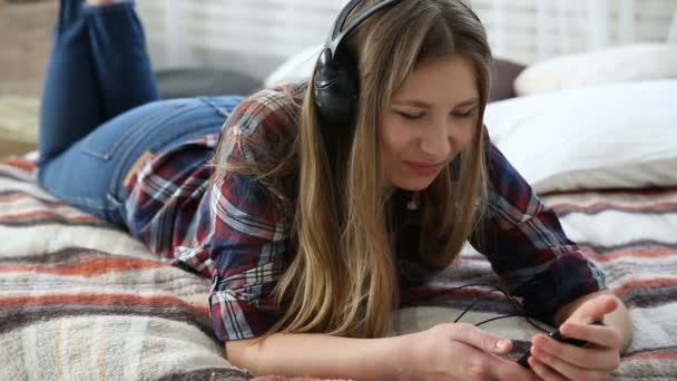 Dispositivi elettronici nella vita della gioventù moderna. giovane adolescente che riposa a casa sul letto con il telefono cellulare . — Video Stock