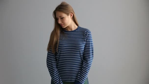灰色の背景にカジュアルな服装で欧州外観のブロンドの女の子の肖像画 — ストック動画