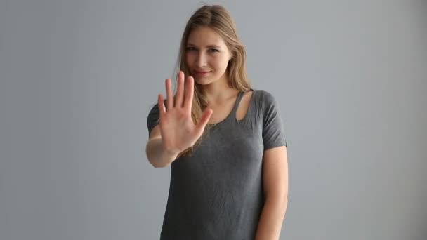 Πορτρέτο του ένα ξανθό κορίτσι της Ευρωπαϊκής εμφάνιση με casual ρούχα σε ένα γκρίζο φόντο — Αρχείο Βίντεο