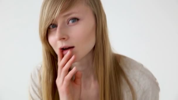 Mooie langharige meisje van Europees uiterlijk, met blond haar kijkt naar haar gezicht close-up — Stockvideo