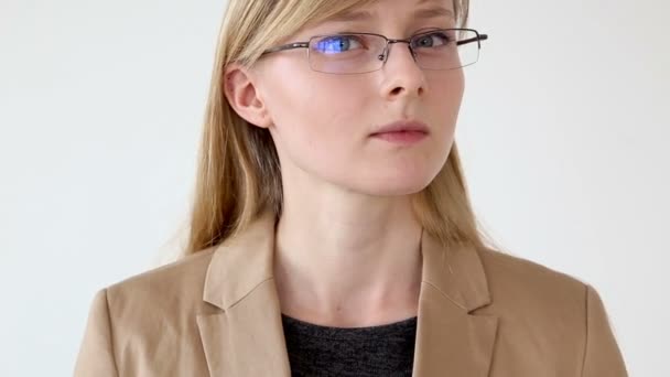 Portrait of a serious business woman in glasses and a jacket close-up on a white background — Stock Video